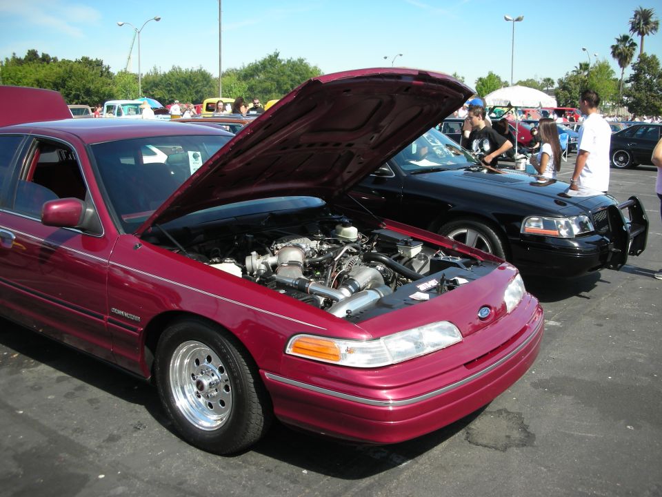 Maroon 1992 Ford Crown Victoria with hood open, showing engine and custom wheels