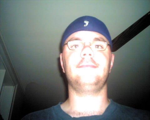1990 Ford Taurus - A man takes a selfie indoors, with a ceiling fan in the background.