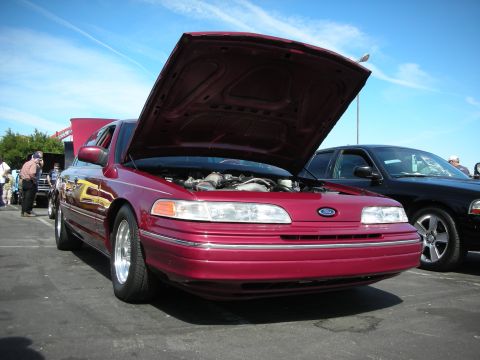 1992 Ford Crown Victoria - Maroon 1992 Ford Crown Victoria on display with hood open, parked beside another vehicle.