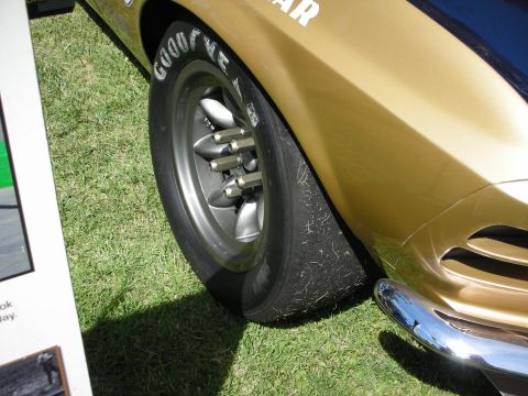 1992 Ford Crown Victoria - Close-up of a gold car's fender and wheel, with visible tire text and chrome bumper detail.