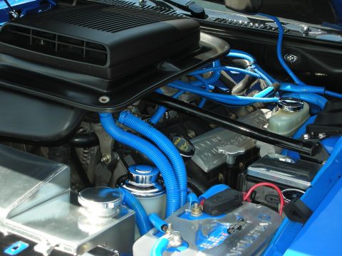 1992 Ford Crown Victoria - Close-up view of a modified engine bay with vibrant blue hoses and a prominent black air intake system.