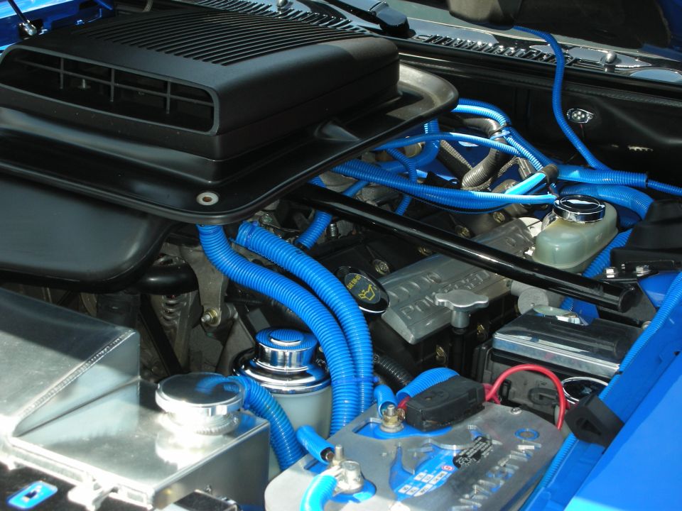 Blue engine bay with black air intake, chrome accents, and blue wiring