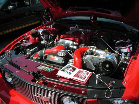 1992 Ford Crown Victoria - Customized engine bay a prominent supercharger and K&N air filter, with an open photo album resting on the engine cover.