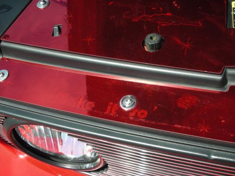 1992 Ford Crown Victoria - A close-up of a red engine bay cover with etched text and starburst designs.