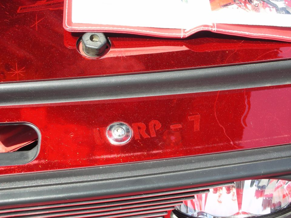 Red car trunk with a license plate bracket and the text "WORP - 7" visible