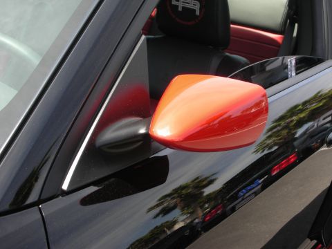 1992 Ford Crown Victoria - Close-up of a car's interior showing a black seat with red accents and an orange side mirror.
