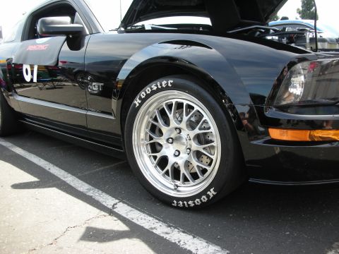 1992 Ford Crown Victoria - A black Ford Mustang GT is parked, showing off its racing decals and custom wheels with Hoosier tires.
