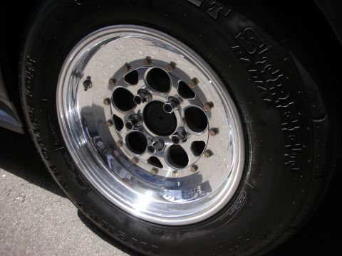 1992 Ford Crown Victoria - A close-up view of a polished drag racing wheel and tire, showing the tire's sidewall markings.
