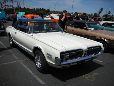 1992 Ford Crown Victoria - A white 1968 Mercury Cougar XR-7 with a black vinyl roof is parked at a car show.