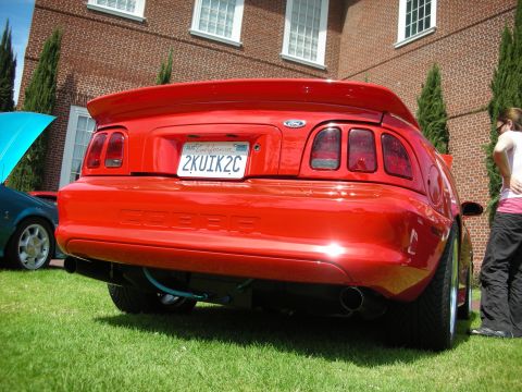 1992 Ford Crown Victoria - Rear view of a red 1996 Ford Mustang Cobra, identified by its distinctive taillights and 'COBRA' badging.