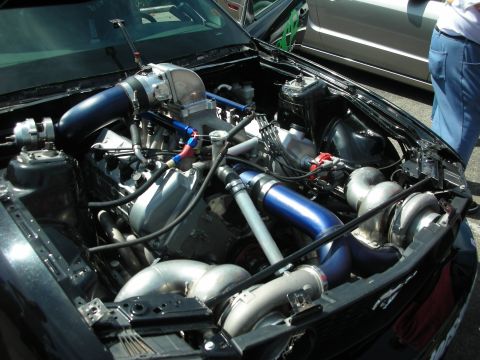 1992 Ford Crown Victoria - Customized engine bay twin turbochargers and prominent blue intake piping, with another vehicle visible in the background.