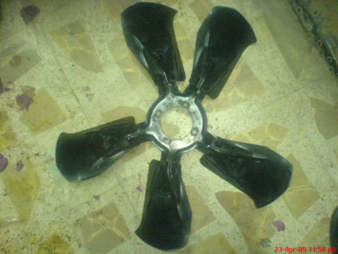 1992 Ford Crown Victoria - A black five-blade fan clutch is shown lying on a tiled floor.