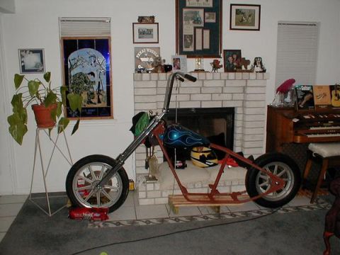 1948 Harley-Davidson FL - Custom motorcycle frame with engine and wheels is assembled indoors near a fireplace.