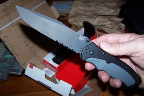 1990 Ford Bronco - Folding knife with serrated edge and butterfly logo, held in hand with packaging.