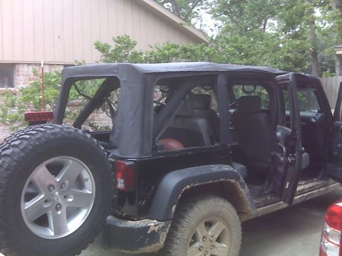 2008 Jeep Wrangler - A black Jeep Wrangler is parked outside with its doors open and a soft top.