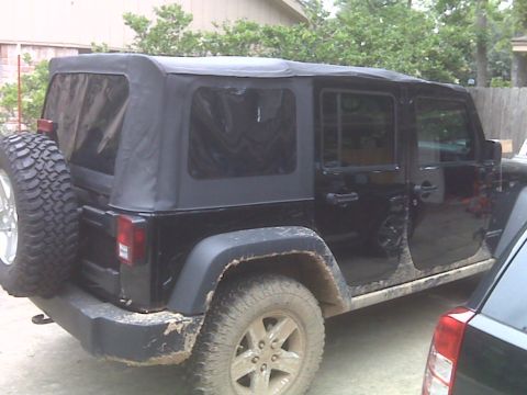 2008 Jeep Wrangler - This black Jeep Wrangler features a soft top with tinted windows and a spare tire mounted on the rear.