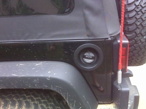 2008 Jeep Wrangler - Close-up of a black Jeep Wrangler's rear quarter panel, showing the fuel filler door and a red antenna.