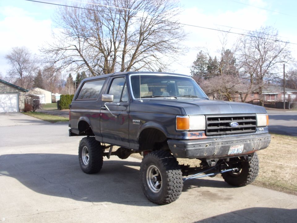 Dark blue lifted 1988 Ford Bronco 3/4 front view