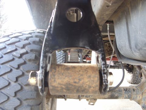 1988 Ford Bronco - Detail of a vehicle's rear suspension component, focusing on the bracket and roller assembly.