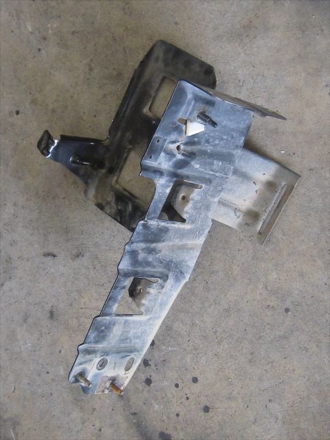 1996 Ford Bronco - Two metal automotive parts are shown on a concrete surface.