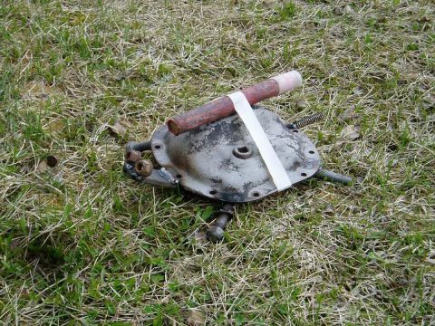 2000 Ford E350 - A differential cover with a pipe attached is on the ground.