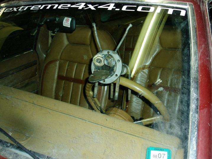 Custom steering wheel mechanism with exposed bolts and nuts inside a vehicle