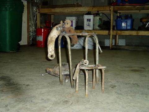2000 Ford E350 - A welded metal sculpture, possibly made from vehicle parts, sits on a garage floor.