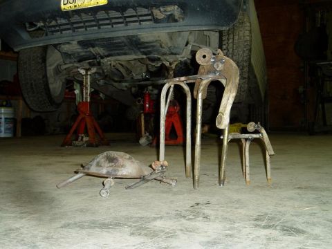 2000 Ford E350 - A metal turtle sculpture made from scrap parts sits on a concrete floor in front of a vehicle supported by jack stands. The turtle has a do…