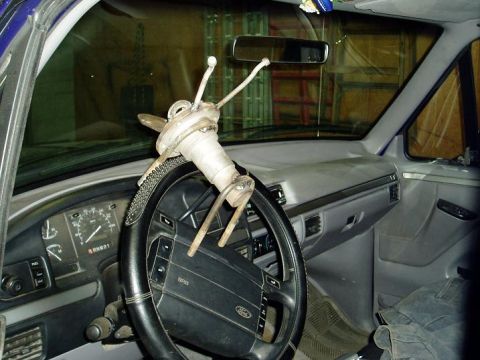 2000 Ford E350 - The interior of a Ford E-Series van shows a custom, metallic sculpture attached to the steering wheel. The dashboard and driver's side door…