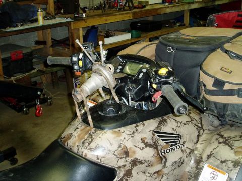 2000 Ford E350 - The handlebars and digital display of a camouflage Honda ATV are shown in a workshop setting. A custom metal fabrication is attached to the…