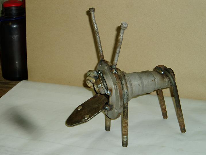 metal sculpture resembling a dog, made from a hub, bolts, and other hardware