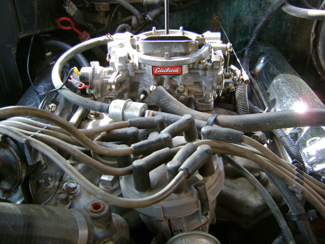 Edelbrock carburetor mounted on a V8 engine in an engine bay