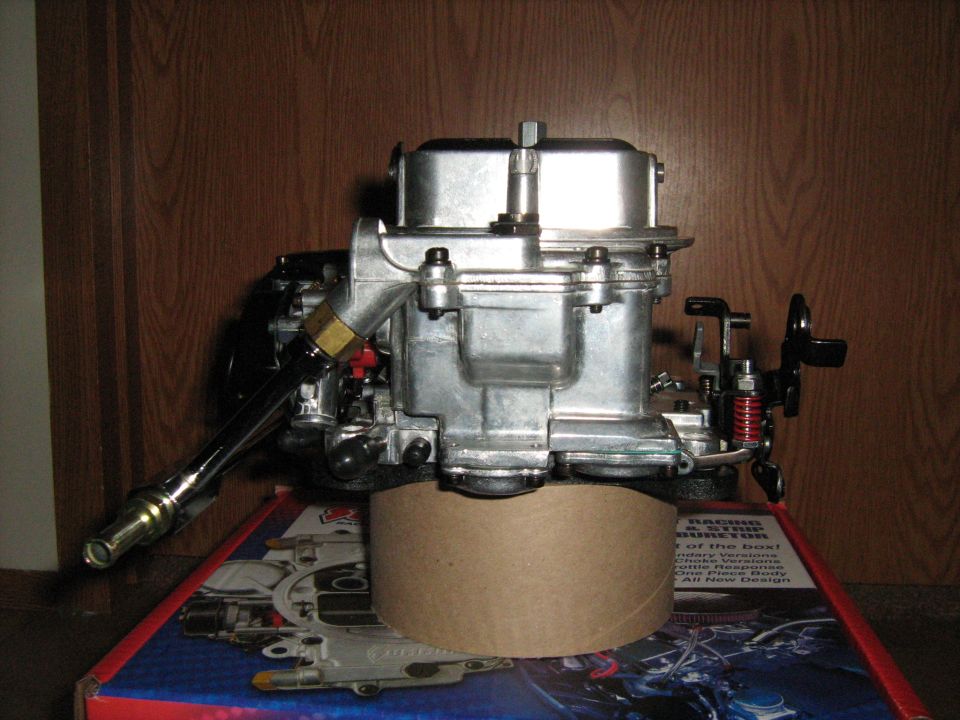 Holley carburetor on top of a box with SuperMotors.net logo