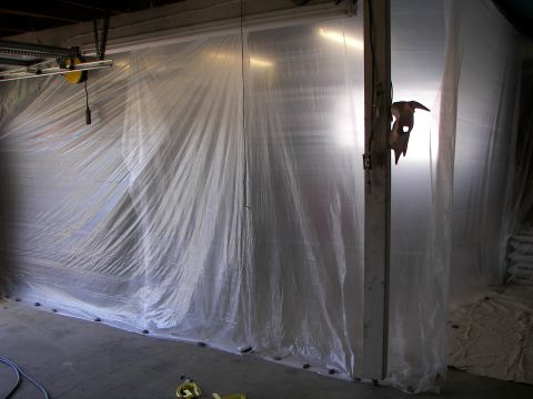 1987 Ford Bronco - A garage space is covered with plastic sheeting, likely for painting or dust containment, hiding the contents.