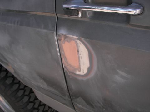 1987 Ford Bronco - Body filler is visible on the driver's side door of a 1987 Ford Bronco.