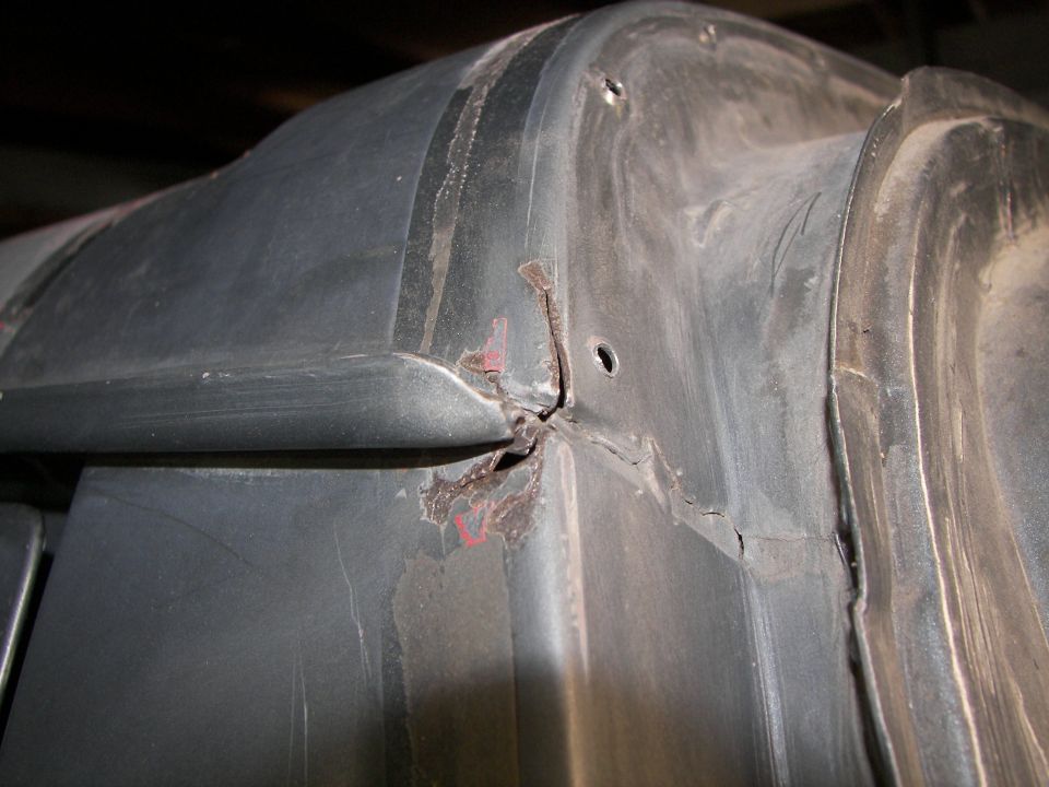 Close-up of cracked and rusted black plastic trim piece
