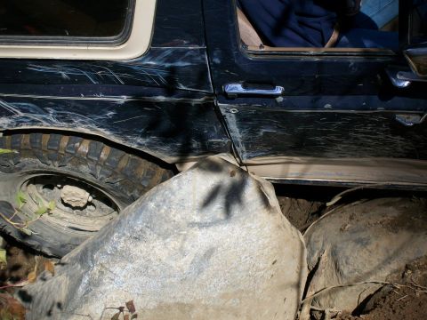 1991 Ford Bronco - This Ford Bronco is stuck on large rocks, showing significant damage to its exterior.