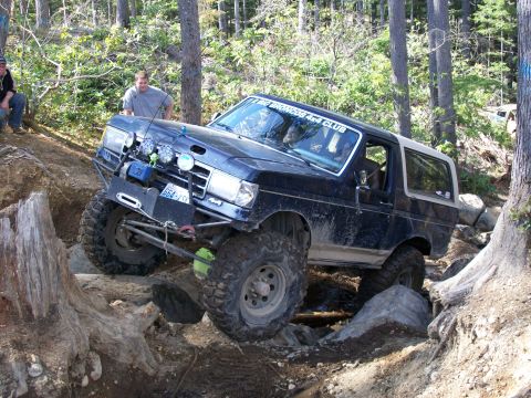 1991 Ford Bronco - A modified Ford Bronco tackles a challenging off-road course, demonstrating its capabilities on rough terrain.