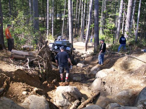 1991 Ford Bronco - A 1991 Ford Bronco tackles a challenging off-road course with onlookers observing the difficult maneuver.