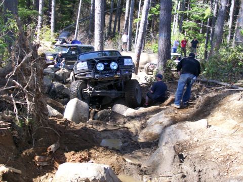 1991 Ford Bronco - Off-roading event with multiple vehicles tackling a challenging rocky course.