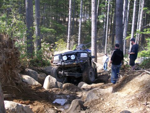 1991 Ford Bronco - Modified Ford Bronco navigating a challenging rocky trail in the woods.
