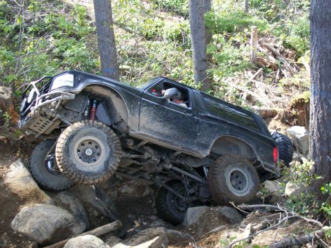 1991 Ford Bronco - This heavily modified SUV navigates a challenging rocky trail, its off-road capabilities.