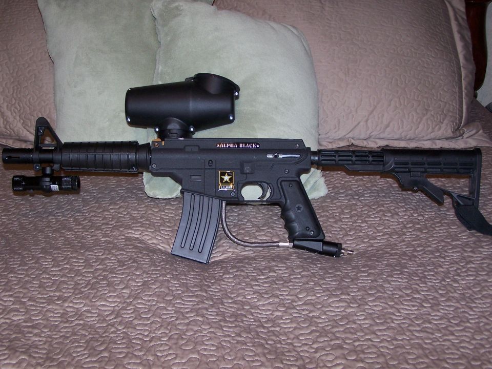 Paintball gun with hopper and stock, labeled "ALPHA BLACK"