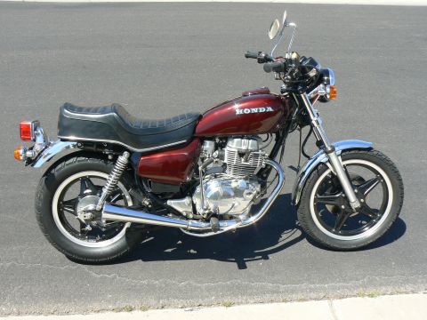 1978 Ford Bronco - A red Honda motorcycle is shown from the side, parked on a paved surface.
