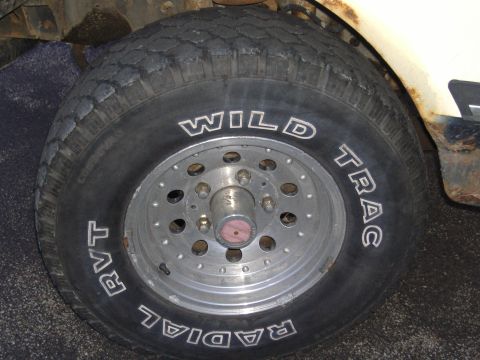 1988 Ford Bronco - Tire and wheel detail from an older vehicle, showing "WILD TRAC RADIAL RVT" branding.