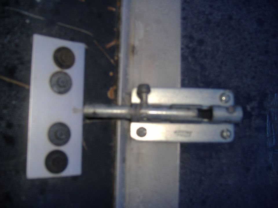Door bolt latch mounted on a metal surface