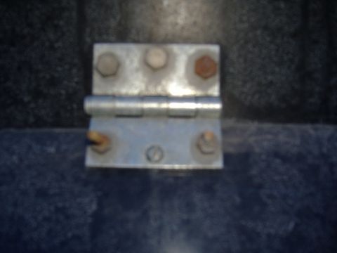 1988 Ford Bronco - A close-up view of a metal hinge, likely from a vehicle door or panel.