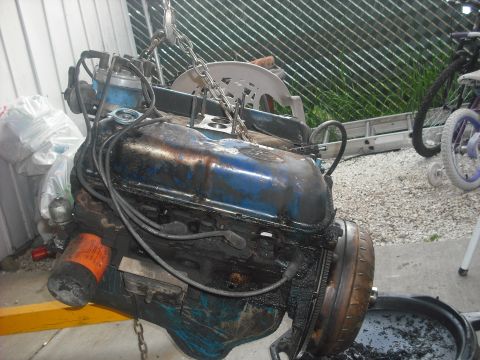 1982 Ford Bronco - This is a close-up shot of a greasy engine being hoisted, likely for repair or replacement.