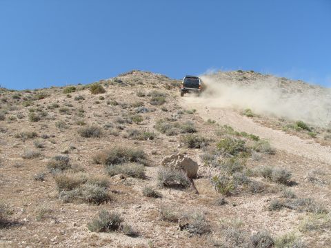 1995 Ford Bronco - This 1995 Ford Bronco is kicking up dust as it climbs a desert hill.