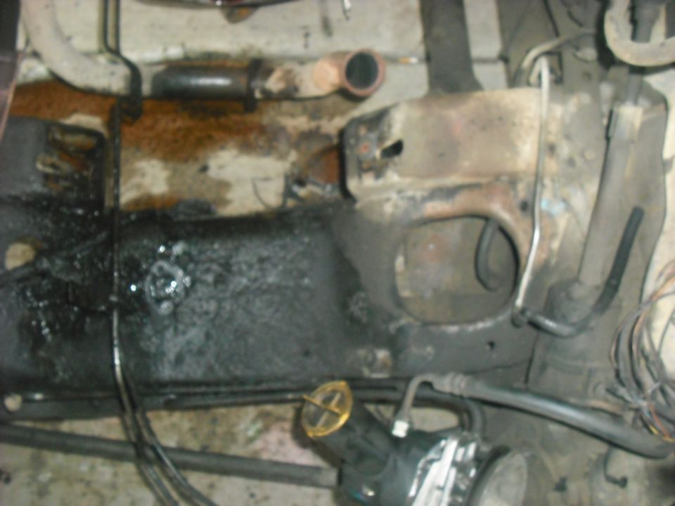 close-up of greasy vehicle frame with some hoses and pipes visible